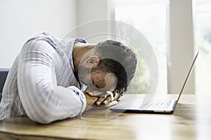 Portrait of a sad and depress mexican businessman working at modern home office with computer laptop