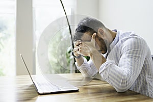 Portrait of a sad and depress mexican businessman working at modern home office with computer laptop