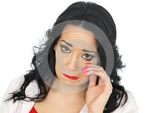 Portrait of a Sad Emotional Disheartened Young Hispanic Woman Wiping Tears Away photo