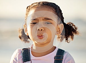 Portrait, sad and face of an unhappy little girl feeling lonely or upset against a blurred background. Closeup of an