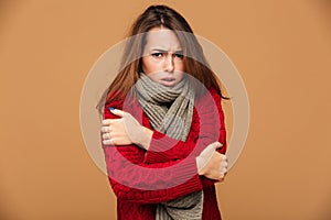 Portrait of sad freezing brunette woman in red knitted sweater s