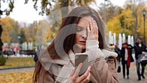 Portrait of sad frustrated girl woman caucasian student chatting by mobile phone outdoors worried lady use smartphone in