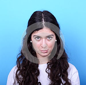 Portrait of sad girl against blue background