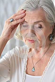 Portrait of sad ill senior woman with headache