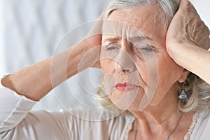 Portrait of sad ill senior woman with headache
