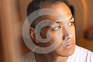 Portrait of sad Japanese young man looking at window