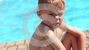 Portrait of a sad little boy near the pool.Slow mo