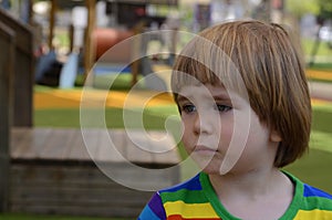 Portrait of a sad little boy in playground
