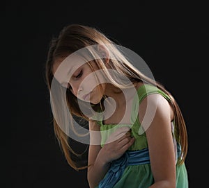 portrait of a sad little girl on black background