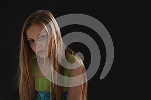 portrait of a sad little girl on black background