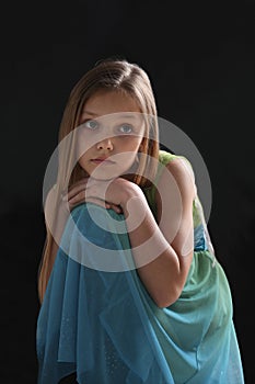 portrait of a sad little girl on black background