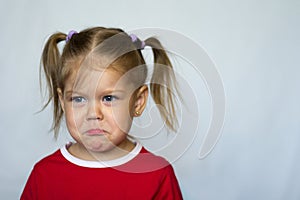 Portrait of sad little girl with blue eyes looking aside on white background