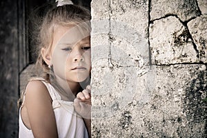 Retrato triste pequeno de pie más cercano piedra muro 