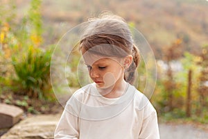 Portrait of a sad little girl in a white T-shirt