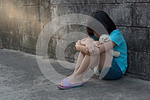 Portrait of a sad and lonely Asian girl against grunge wall back