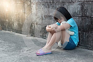 Portrait of a sad and lonely Asian girl against grunge wall back