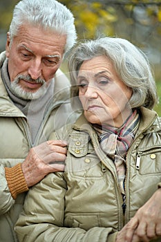 Portrait of sad senior couple in park