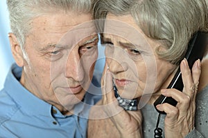 Portrait of sad senior couple portrait with phone