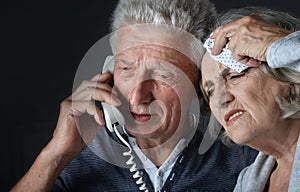 Portrait of sad senior couple portrait with phone