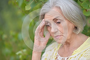 Portrait of sad seniour woman in park