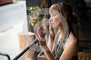 Portrait of a sad Serbian woman longingly looking out of the window photo