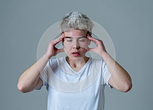Portrait of sad teenager man in emotional pain having headache and migraines