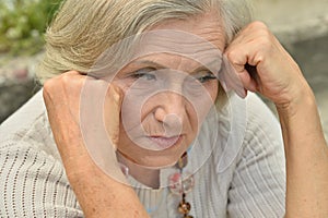 Portrait of sad, thoughtful senior woman in park