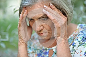 Portrait of sad, thoughtful senior woman in park