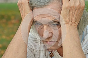 Portrait of sad, thoughtful senior woman in park