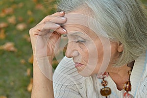 Portrait of sad, thoughtful senior woman in park