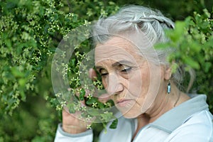 Portrait of sad, thoughtful senior woman in park