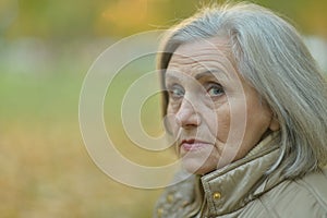 Portrait of sad, thoughtful senior woman in park