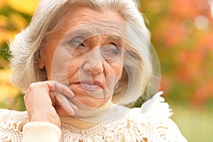 Portrait of sad, thoughtful senior woman in park