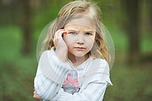 Portrait of sad unhappy little girl. Little sad child is lonesome. upset and distraught angry facial expression.