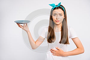 Portrait of sad upset girl hold hand feel hungry have stomach ache want eat more unhealthy dieting concept hold plate photo