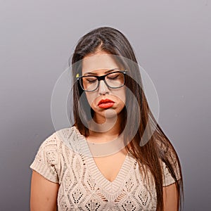 Portrait of a sad woman against gray background