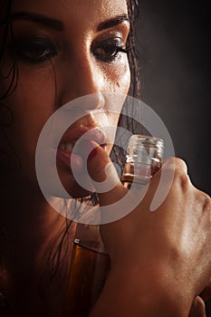 Portrait of sad woman with bottle of alcohol drink