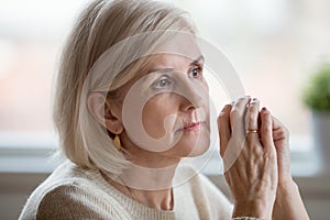 Portrait of sad woman cogitating sitting at home alone