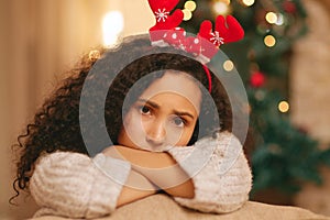 Portrait, sad woman and depression on Christmas in home with anxiety, worry and emotional crisis. Face of lonely female