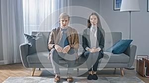 Portrait of Sad Young Couple on a Counseling Session with Therapist. Sitting on a Couch, Looking at