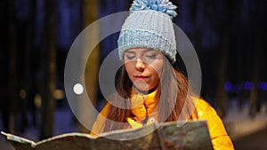 Portrait of sad young woman with paper map standing outdoors thinking looking at camera sighing. Lost Caucasian female