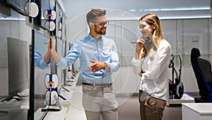 Portrait of salesman helping to woman to buy a new digital device in tech shop