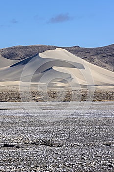 Portrait of Sand Mountain OHV park dune from far away lit by morning light with salt flats in the foreground photo