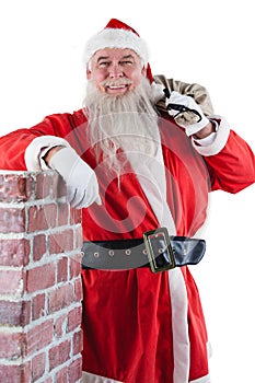 Portrait of santa claus carrying bag full of gifts