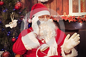 Portrait of santa claus talking to mobile phone at his home for