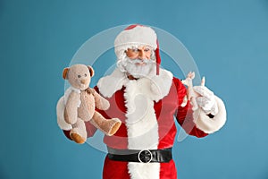 Portrait of Santa Claus with toys on color background