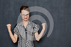 Portrait of satisfied girl showing hooray gesture with fists