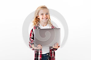 Portrait of a satisfied little girl holding laptop computer