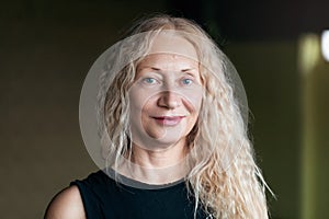 Portrait of a satisfied middle-aged blonde woman looking at the camera