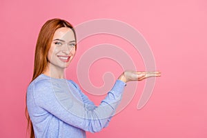 Portrait of satisfied nice girl with foxy hairdo wear blue pullover holding offer on palms empty space isolated on pink